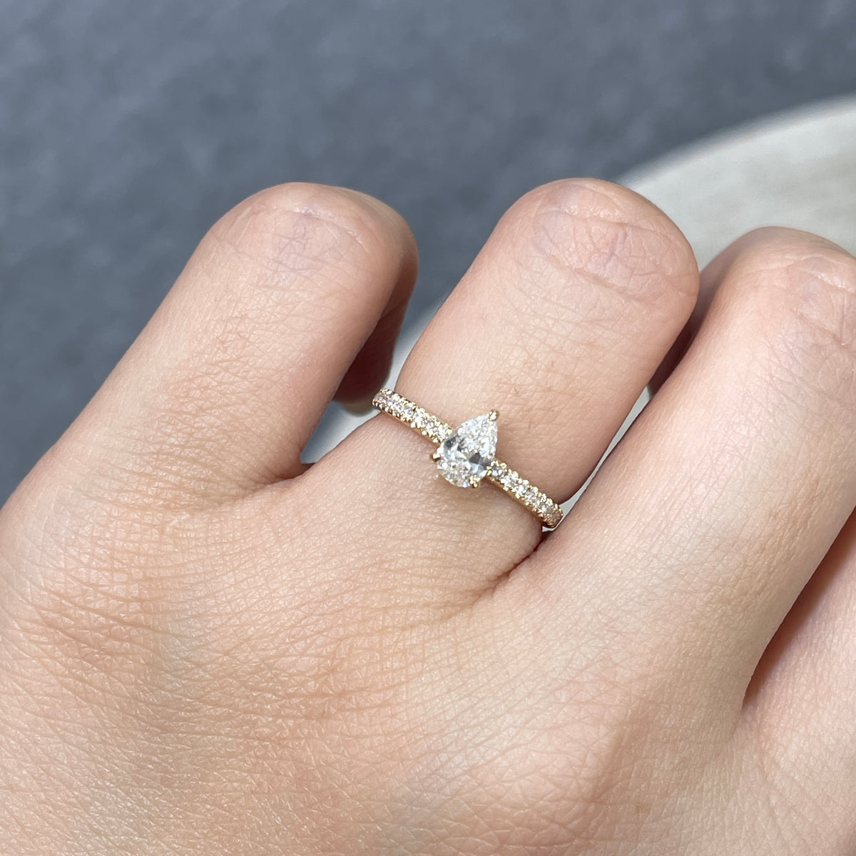 9k Lab diamond pear 0.6ct three-prong ¾ coverage pave ring