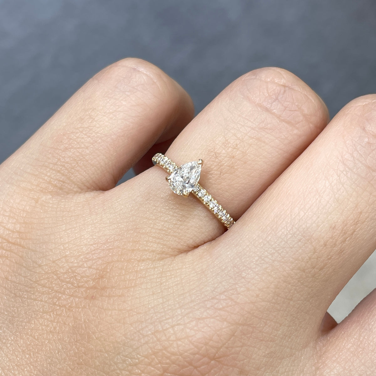 9k Lab diamond pear 0.6ct three-prong ¾ coverage pave ring