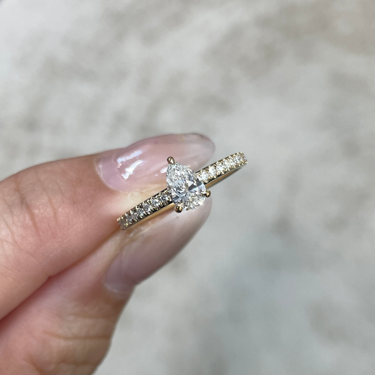 9k Lab diamond pear 0.6ct three-prong ¾ coverage pave ring